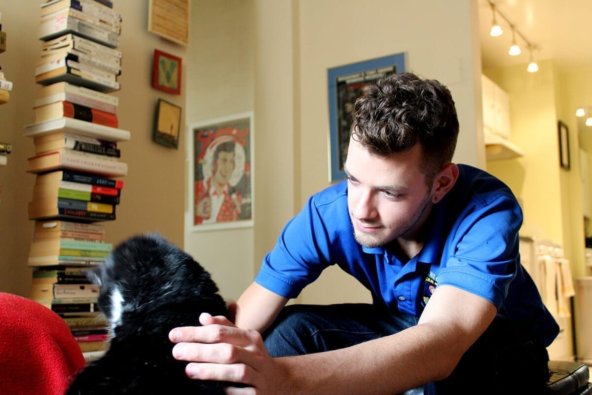 Staff member caring for a special needs cat at home